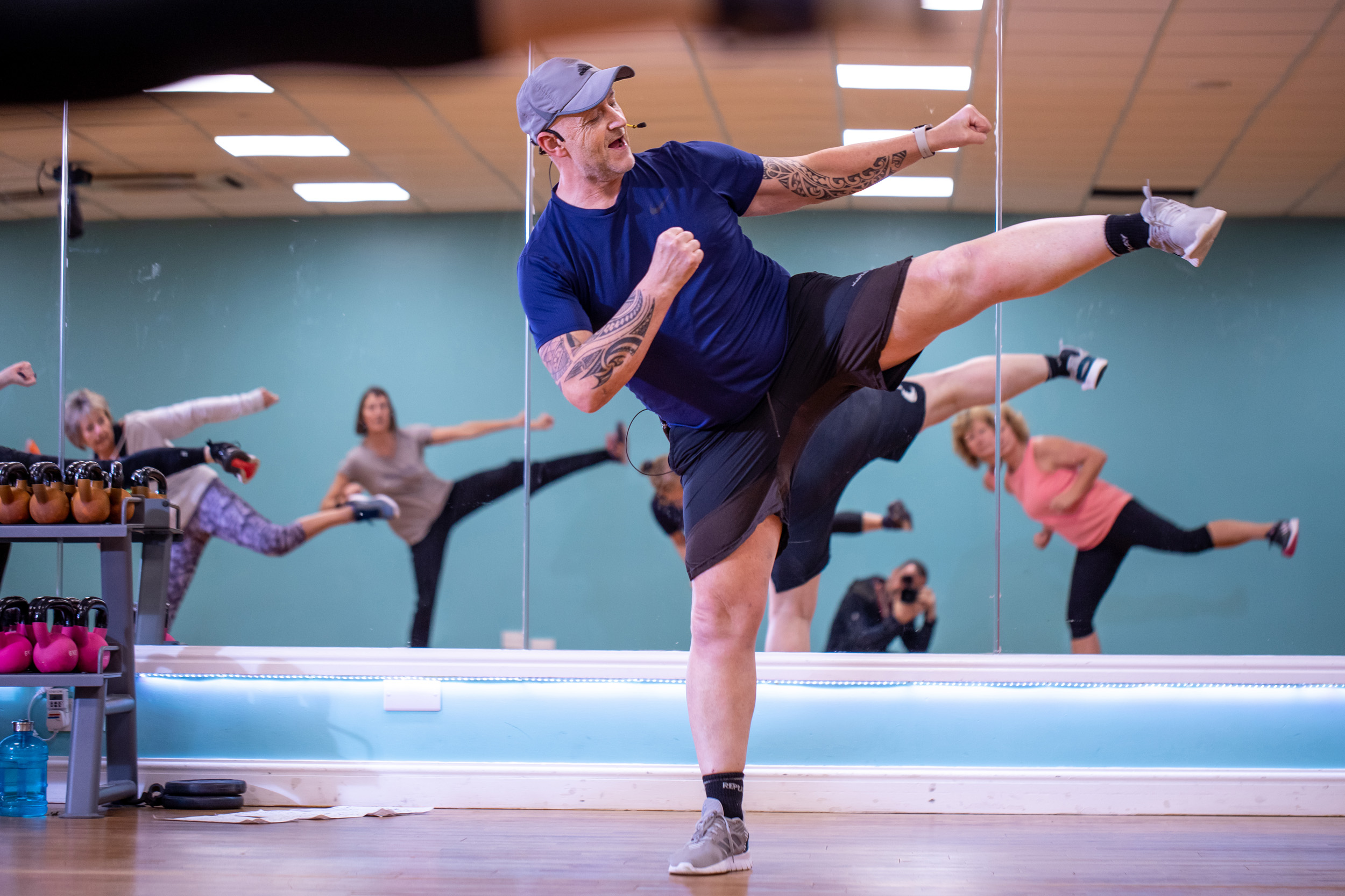 Man in a fitness studio kicking his leg out