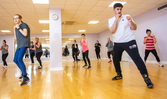 Men and women taking part in a fitness class at Castle Leisure Centre