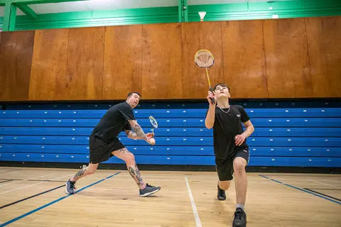 Male doubles game of badminton in the sports hall