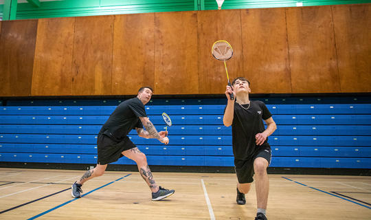 Male doubles game of badminton in the sports hall