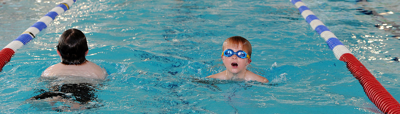 Two children swimming in a lane in a swimming pool