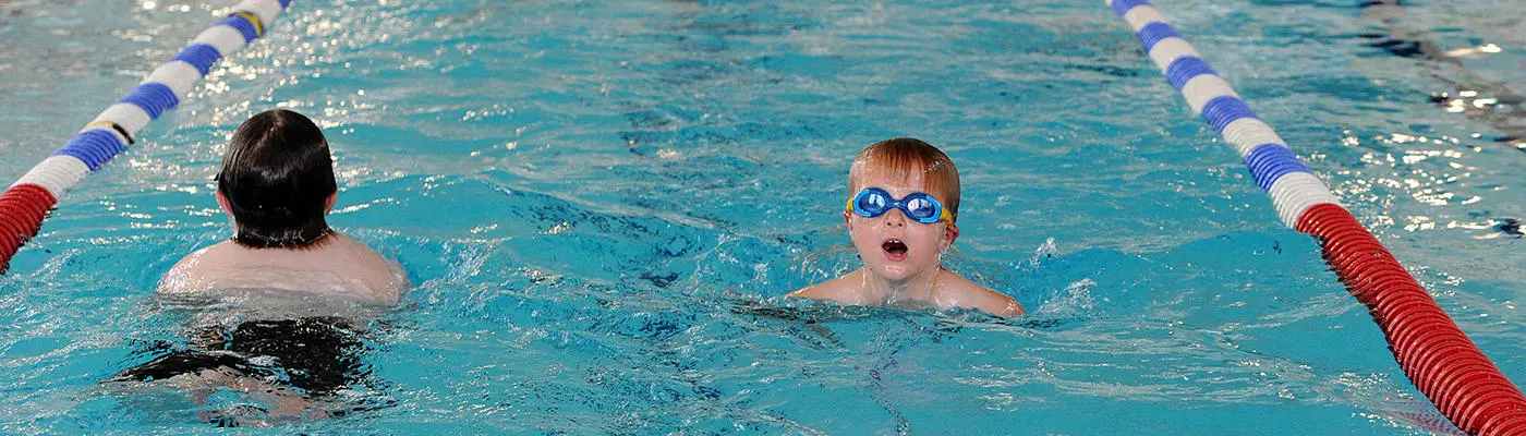 Two children swimming in a lane in a swimming pool