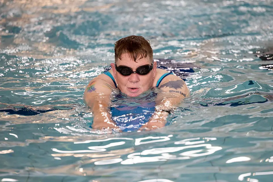 Person swimming with a buoyancy aid (float)