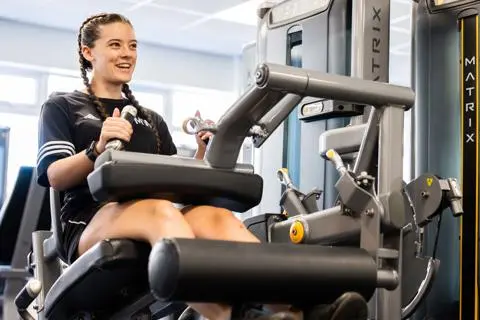 Young woman using strength equipment in the gym at Castle Leisure Centre