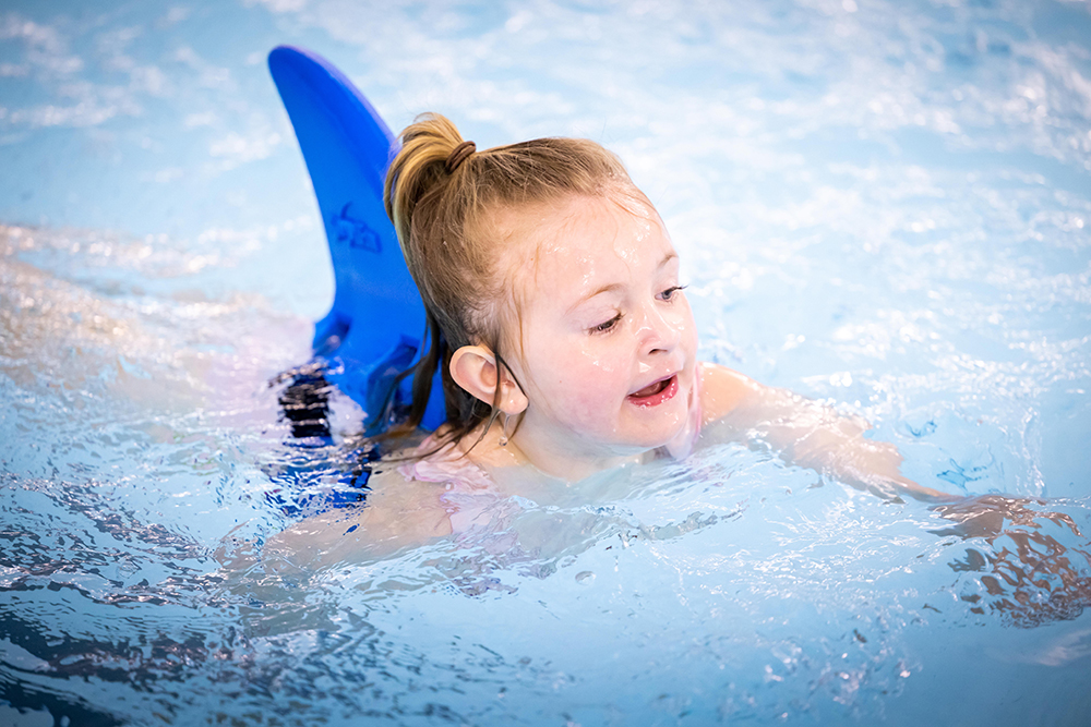 Girl swimming with swimming wings
