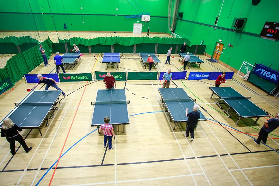 Table tennis tables and participants in the sports hall